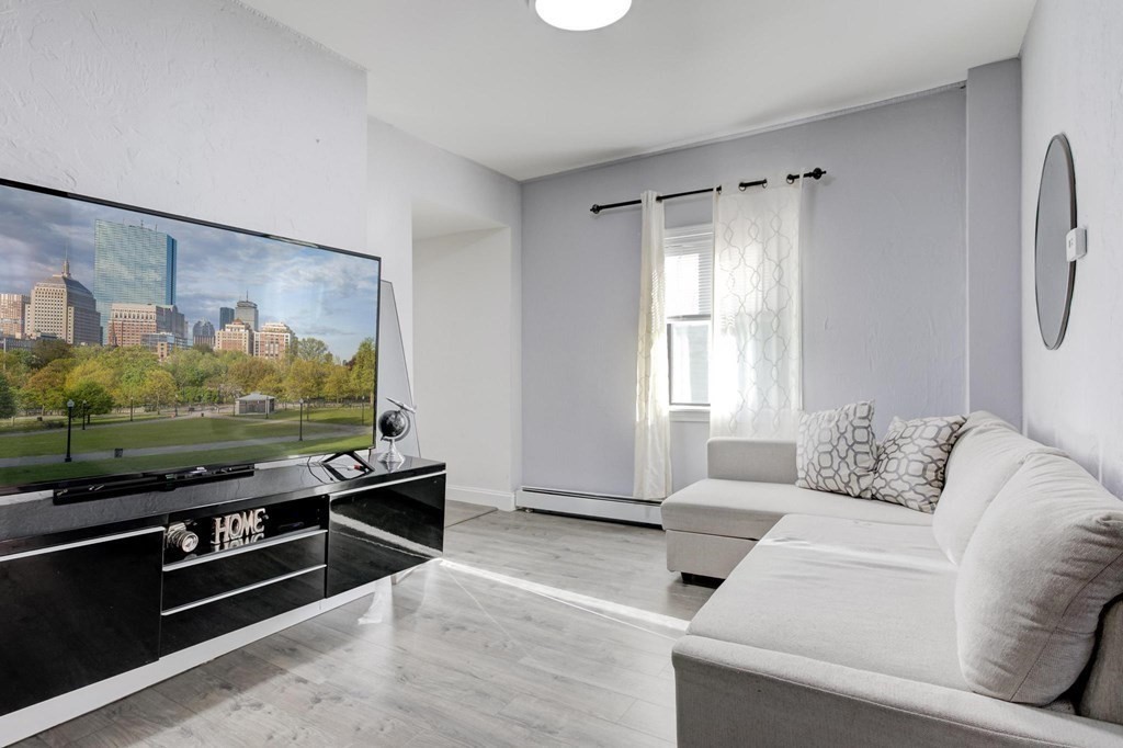 51 Prospect Street Woburn, MA 01801 - Photo 18 of 40 a living room with furniture flat screen tv and a window