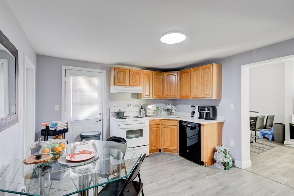 51 Prospect Street Woburn, MA 01801 - Photo 25 of 40 a kitchen with stainless steel appliances granite countertop a sink dishwasher and cabinets with wooden floor