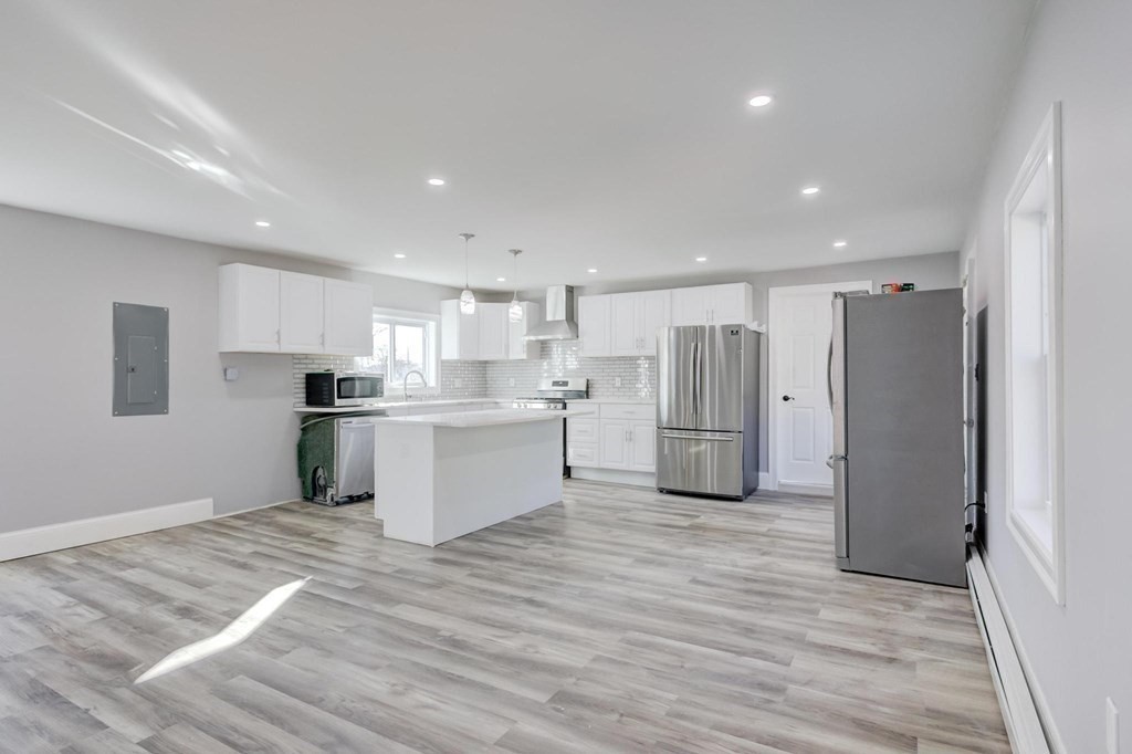 51 Prospect Street Woburn, MA 01801 - Photo 36 of 40 a kitchen with stainless steel appliances granite countertop a refrigerator sink and white cabinets