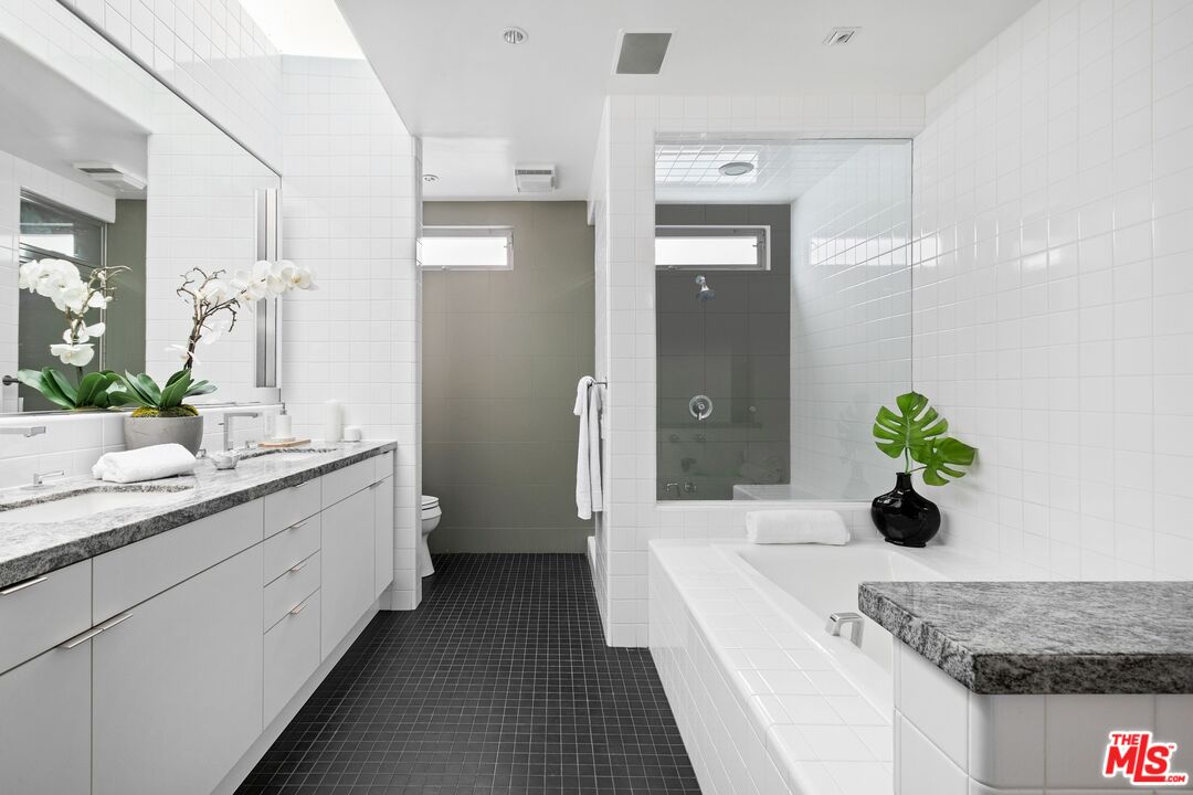 216 Grand Boulevard Venice, CA 90291 - Photo 16 of 30 a spacious en suite bathroom with a granite countertop double vanity sink and a mirror