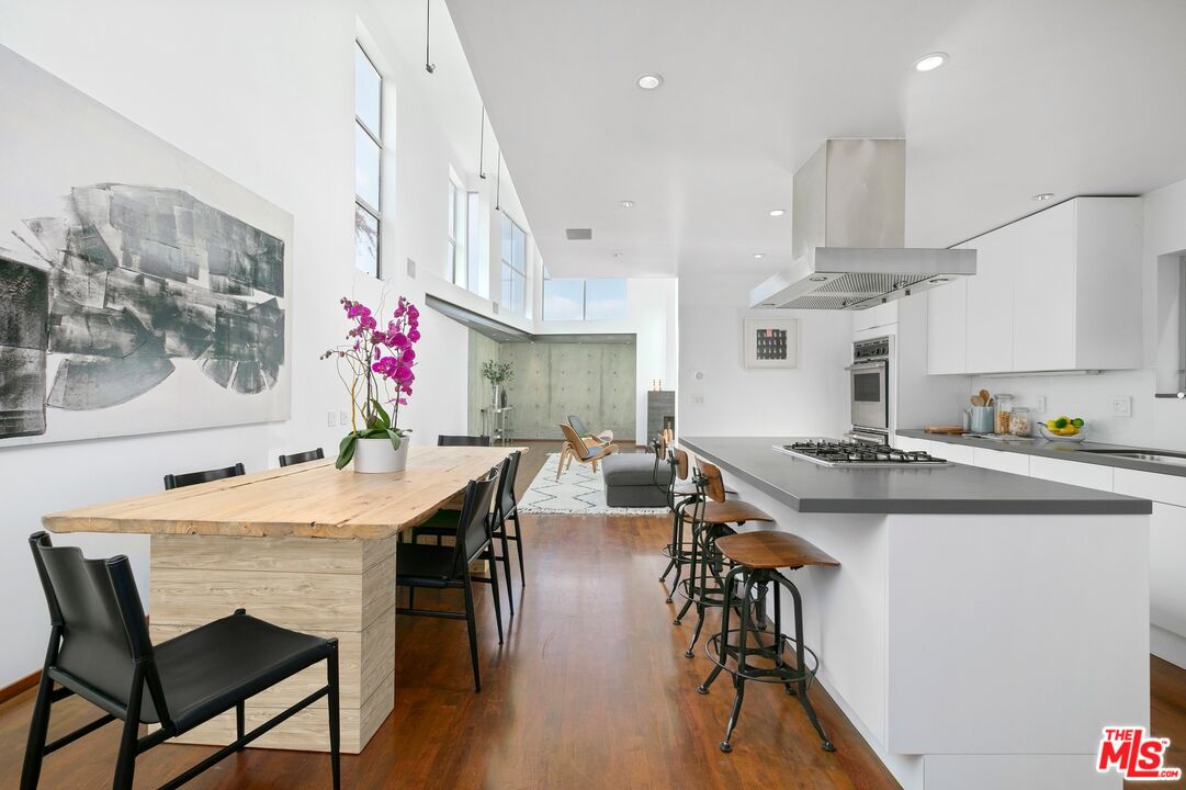 216 Grand Boulevard Venice, CA 90291 - Photo 7 of 30 a kitchen with stainless steel appliances granite countertop a stove a sink dishwasher and a dining table with wooden floor