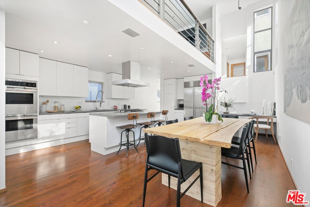 216 Grand Boulevard Venice, CA 90291 - Photo 10 of 30 a kitchen with stainless steel appliances kitchen island granite countertop a table chairs sink and cabinets