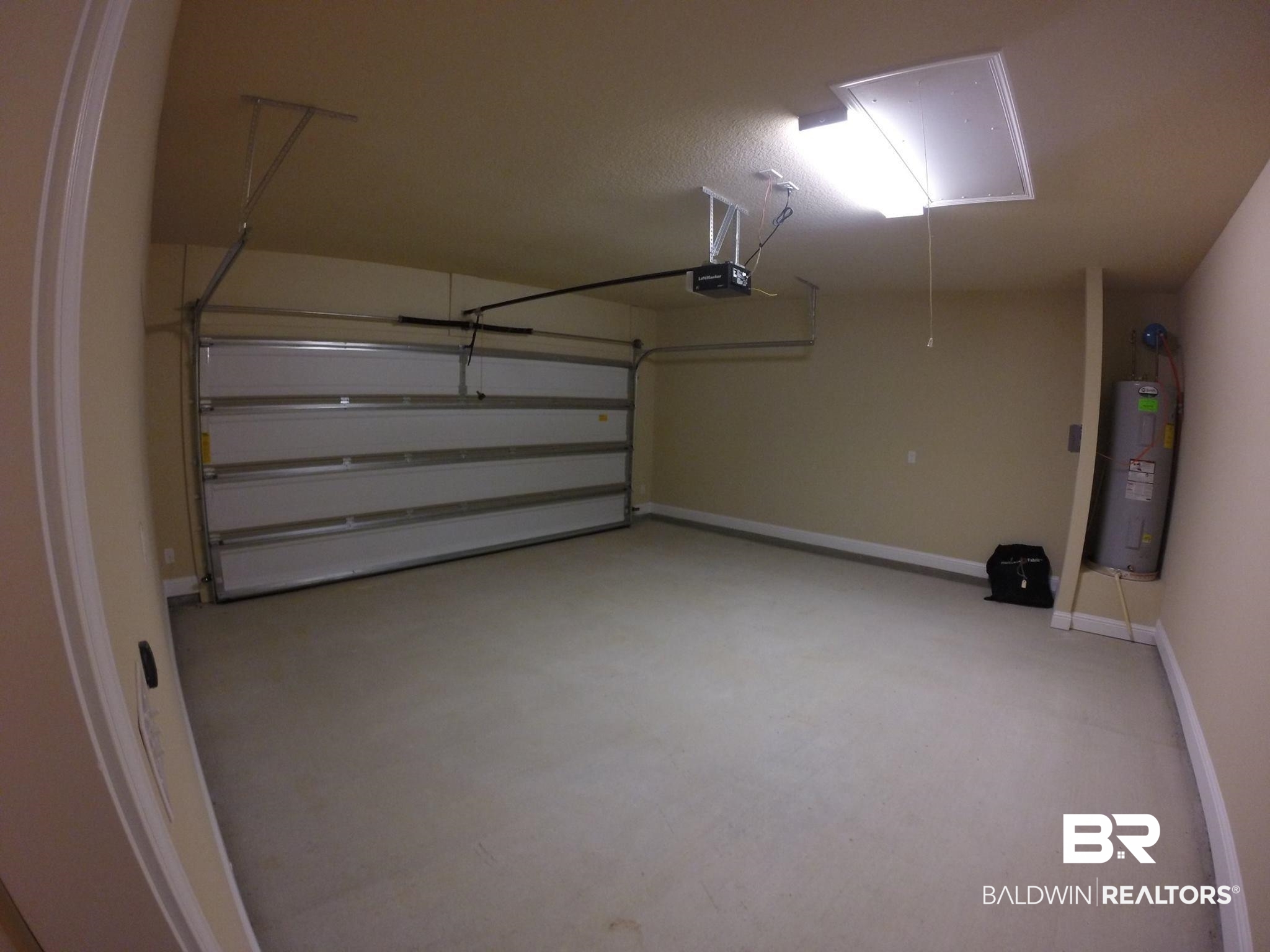 2996 Notsram Court Mobile, AL 36695 - Photo 16 of 16 Garage featuring a garage door opener, electric water heater, and baseboards