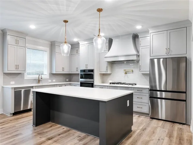 a kitchen with kitchen island a sink granite counter tops and a view of living room