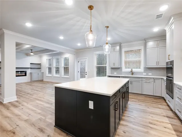 a kitchen with kitchen island a sink stainless steel appliances and cabinets