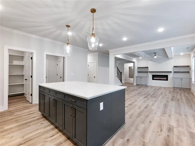 a kitchen with stainless steel appliances kitchen island granite countertop a sink a stove and a refrigerator