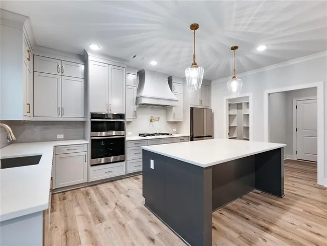 a kitchen with white cabinets and a window