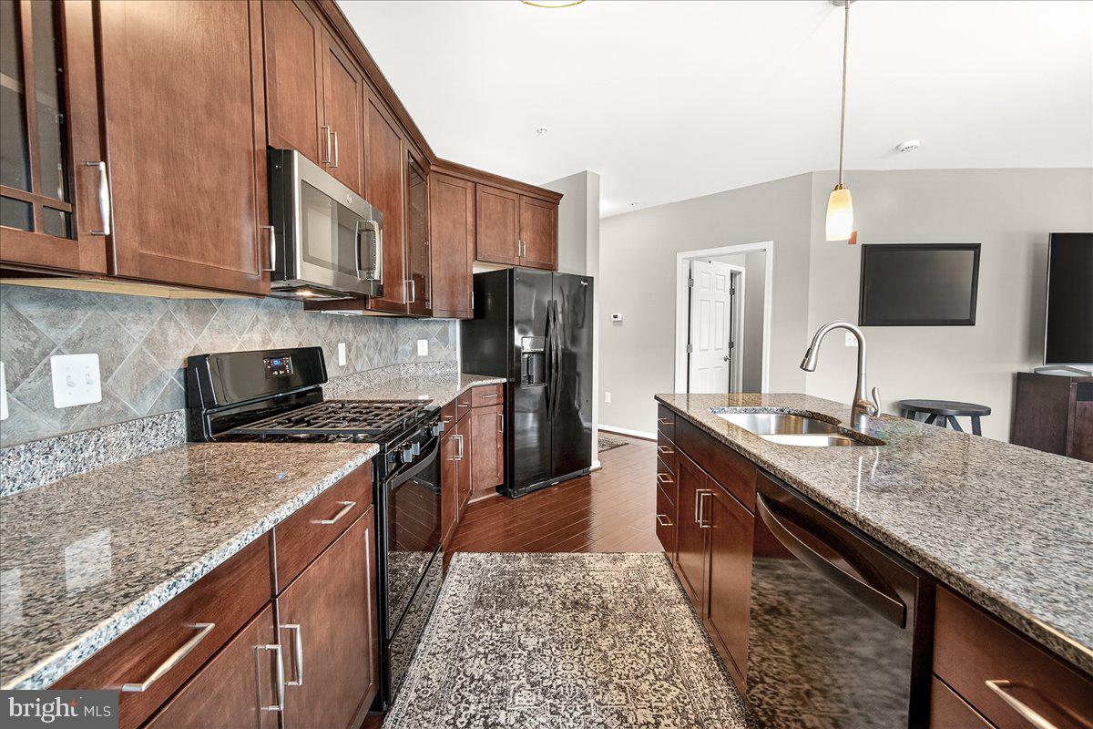 3911 Doc Berlin Drive, Unit 37 Silver Spring, MD 20906 - Photo 12 of 35 a kitchen with stainless steel appliances granite countertop a sink stove and refrigerator