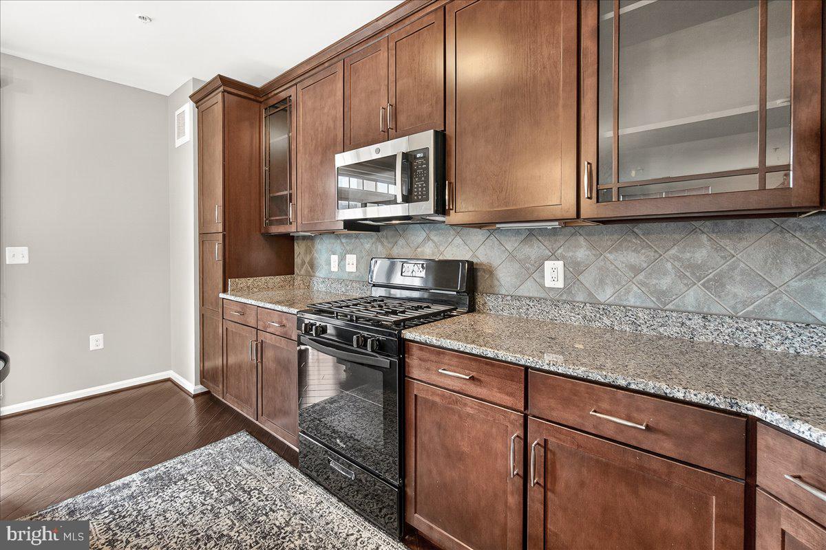 3911 Doc Berlin Drive, Unit 37 Silver Spring, MD 20906 - Photo 14 of 35 a kitchen with stainless steel appliances granite countertop a stove a microwave and cabinets