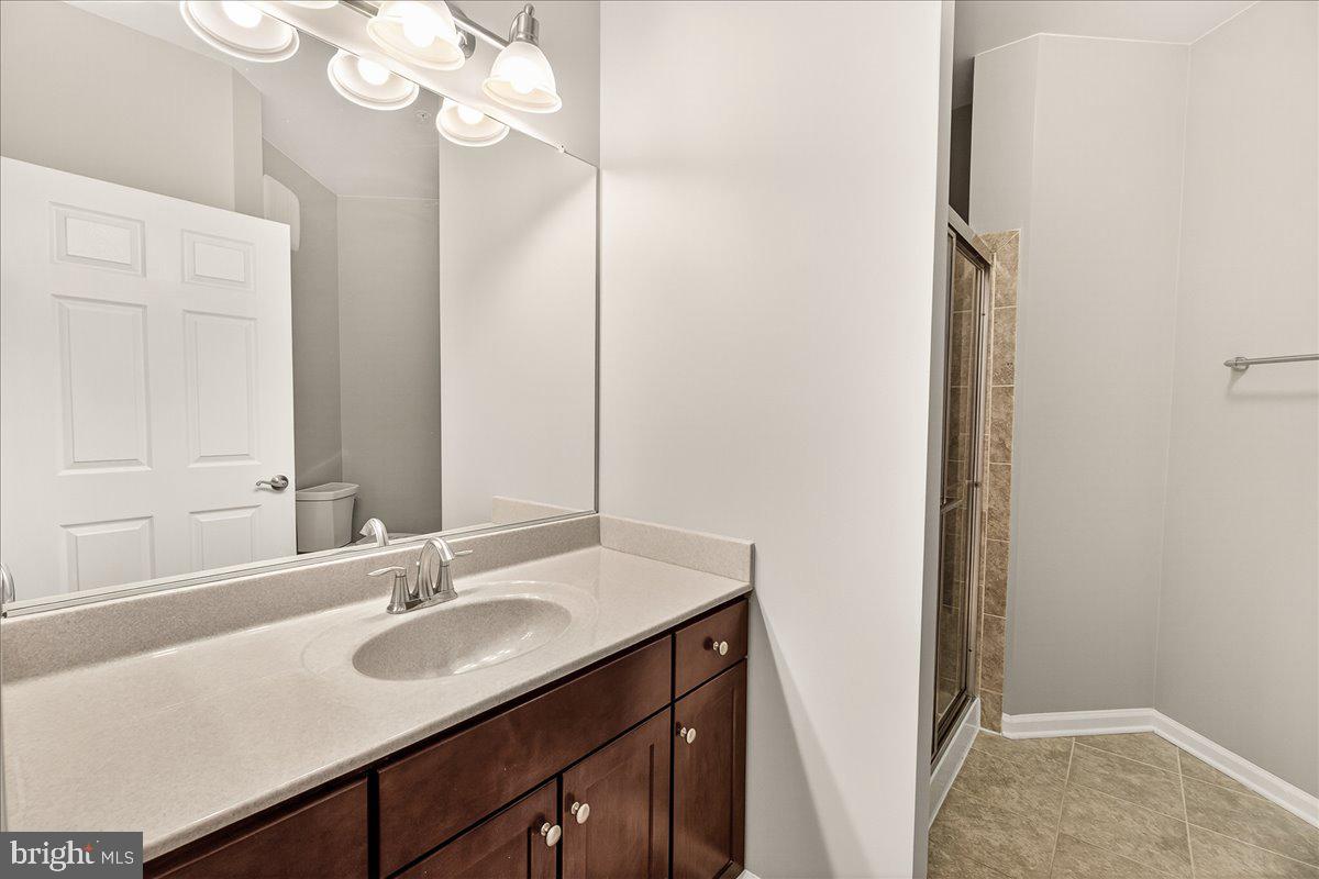 3911 Doc Berlin Drive, Unit 37 Silver Spring, MD 20906 - Photo 25 of 35 a bathroom with a sink vanity granite and a mirror