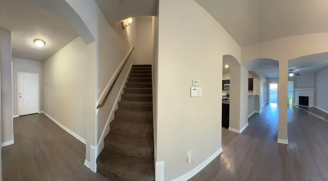 a view of a hallway with wooden floor and stairs