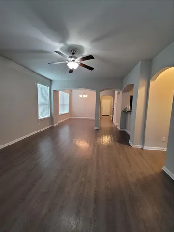 a view of an empty room with a window and wooden floor