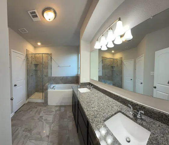 a spacious bathroom with a granite countertop sink a toilet and bathtub