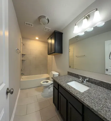 en empty room with windows and chandelier fan