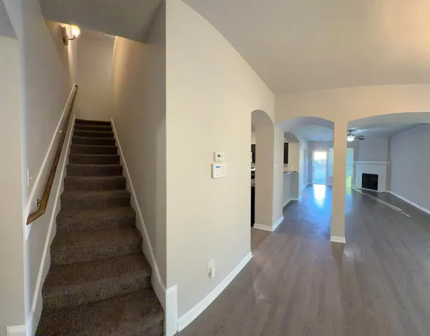 a view of a hallway with wooden floor and entryway