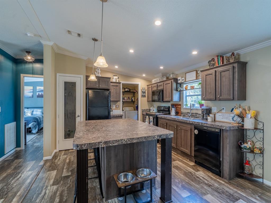 22457 Northeast 130th Court Road Fort McCoy, FL 32134 - Photo 11 of 43 a kitchen with stainless steel appliances granite countertop a kitchen island a stove a refrigerator a oven a dining table and chairs