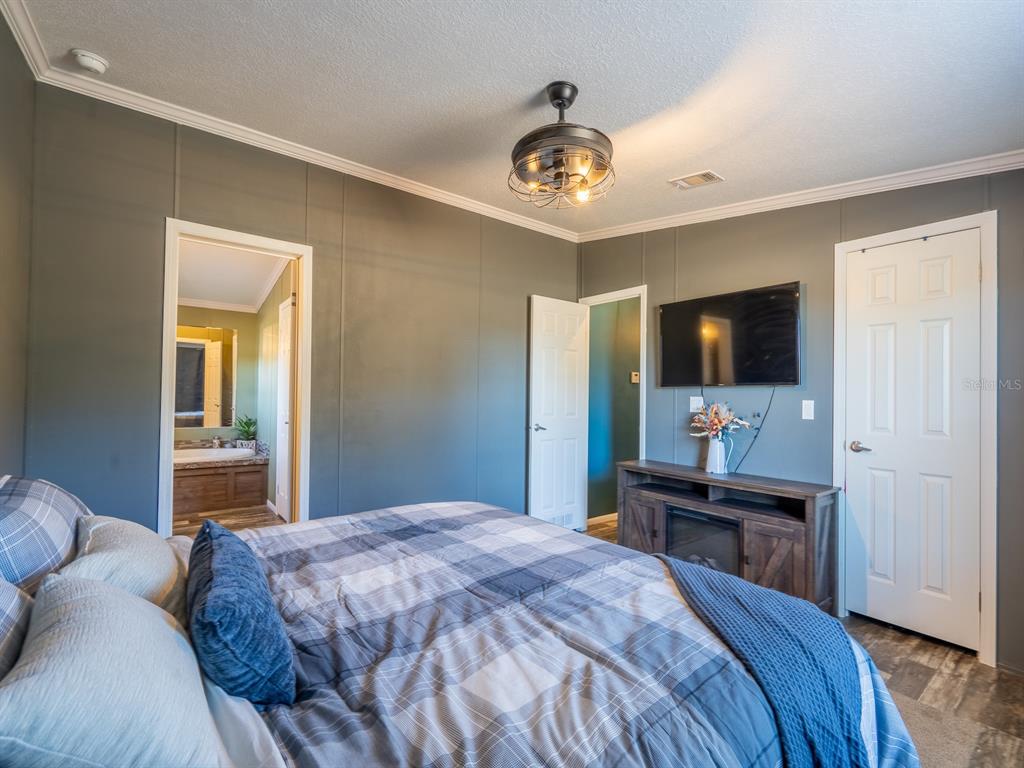 22457 Northeast 130th Court Road Fort McCoy, FL 32134 - Photo 20 of 43 a bedroom with a bed and a flat screen tv