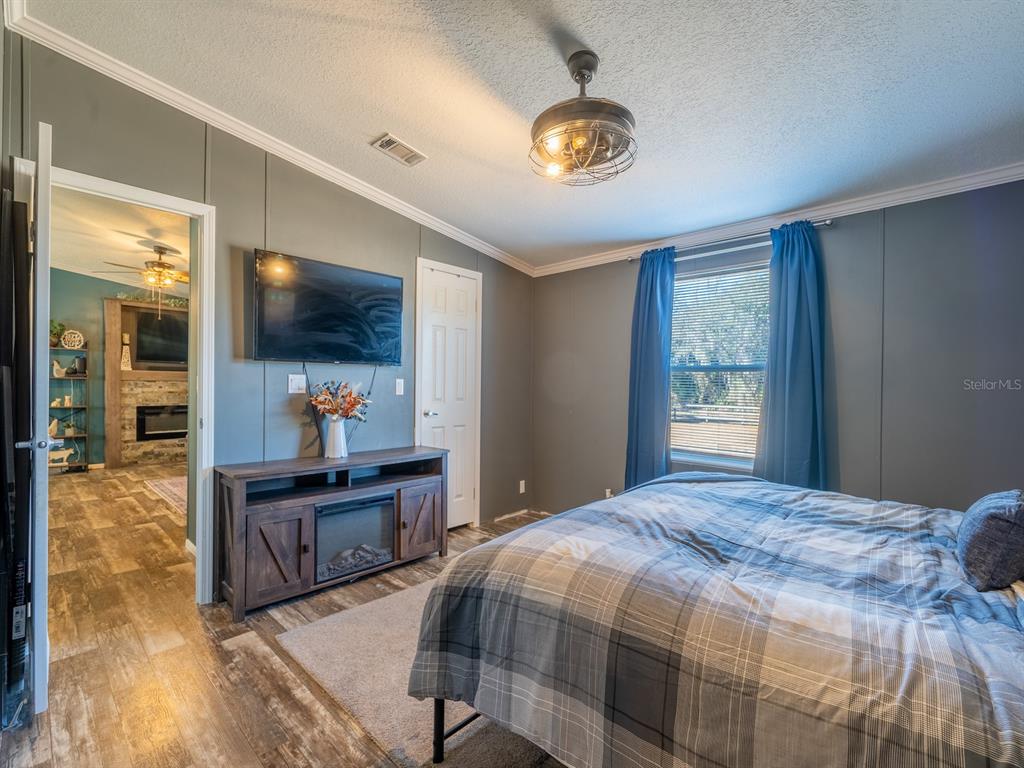 22457 Northeast 130th Court Road Fort McCoy, FL 32134 - Photo 22 of 43 a bedroom with a bed and a flat screen tv