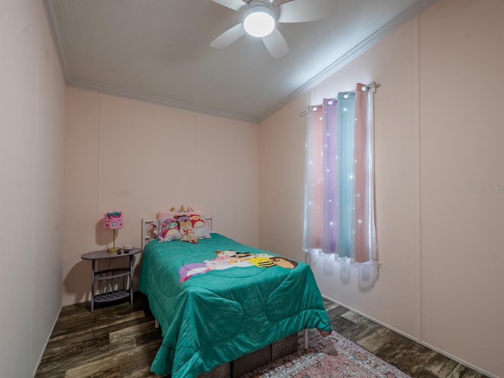 22457 Northeast 130th Court Road Fort McCoy, FL 32134 - Photo 27 of 43 a bedroom with a bed and a chandelier fan