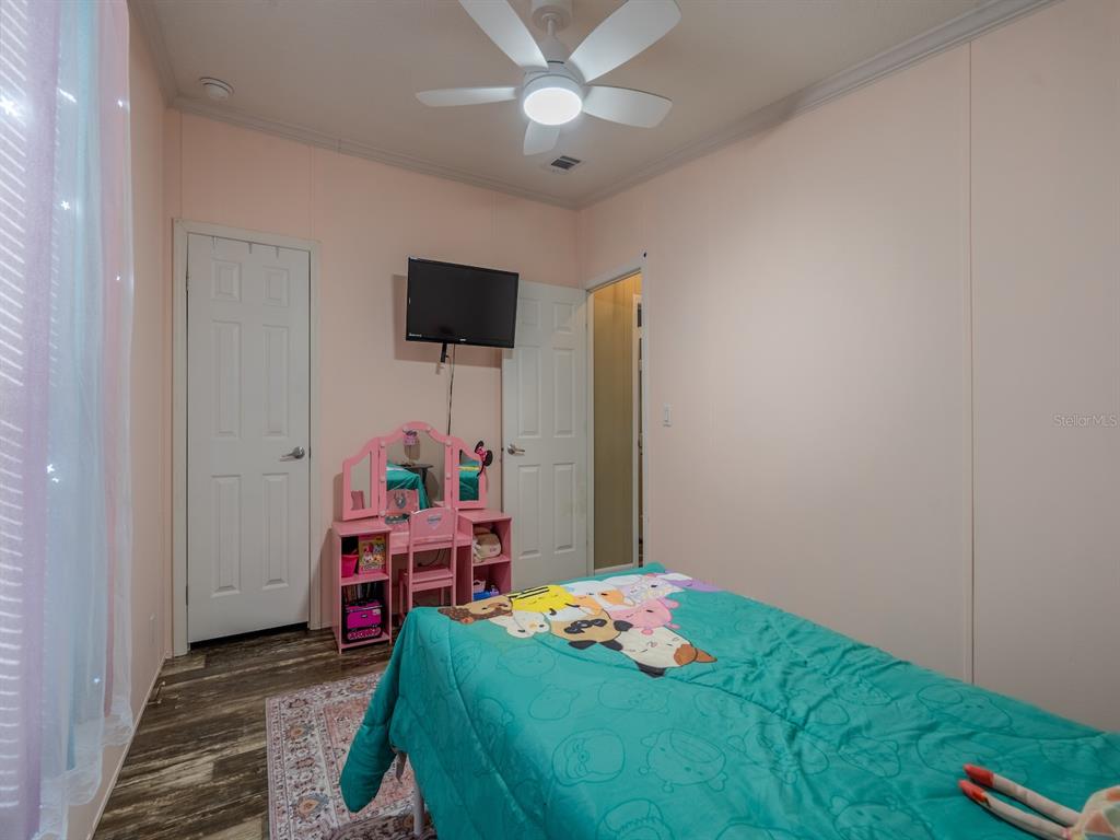 22457 Northeast 130th Court Road Fort McCoy, FL 32134 - Photo 28 of 43 a bedroom with a bed and a chandelier