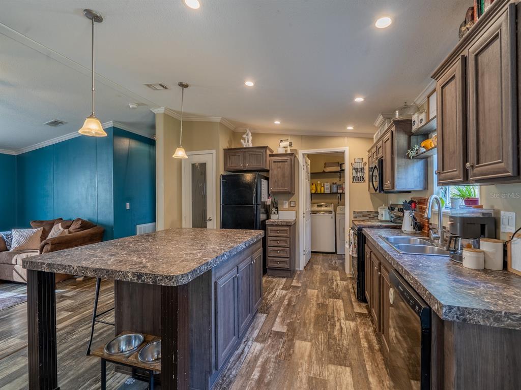 22457 Northeast 130th Court Road Fort McCoy, FL 32134 - Photo 10 of 43 a kitchen with stainless steel appliances granite countertop a kitchen island a stove a refrigerator and a sink