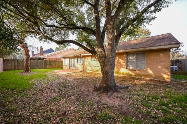a small house with a tree in the grass