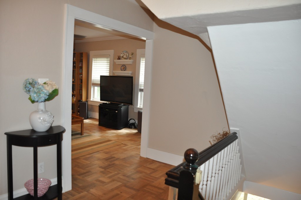 86 Spring Street, Unit B Stoneham, MA 02180 - Photo 8 of 17 a view of a hallway to dining room with wooden floor and stairs
