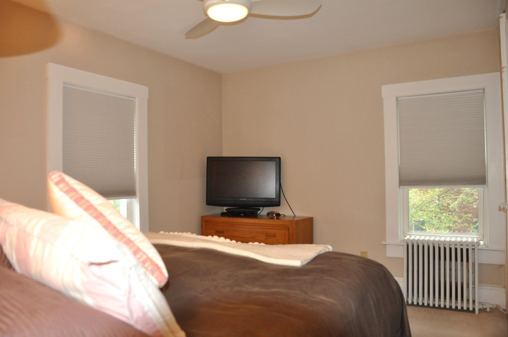 86 Spring Street, Unit B Stoneham, MA 02180 - Photo 9 of 17 a bedroom with a bed and flat screen tv