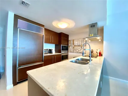 a kitchen with granite countertop a refrigerator and a sink
