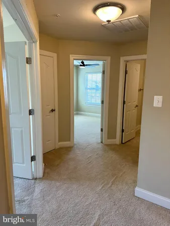 a view of a livingroom with a chandelier fan and windows