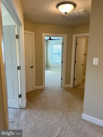 a view of a livingroom with a chandelier fan and windows