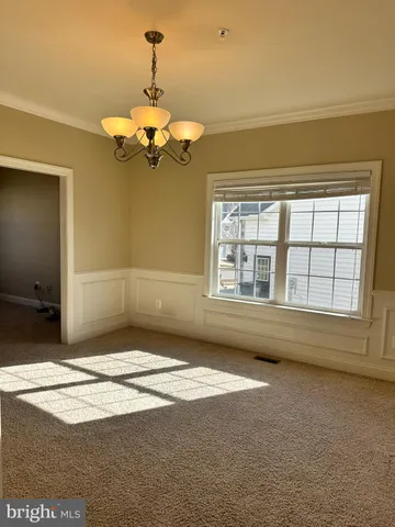 a view of a hallway with wooden floor and a living room