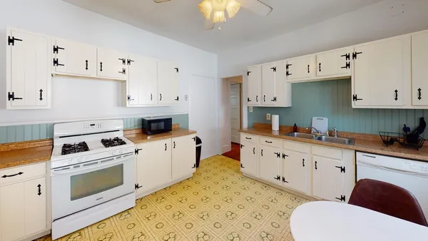 a kitchen with granite countertop a white cabinets and white appliances