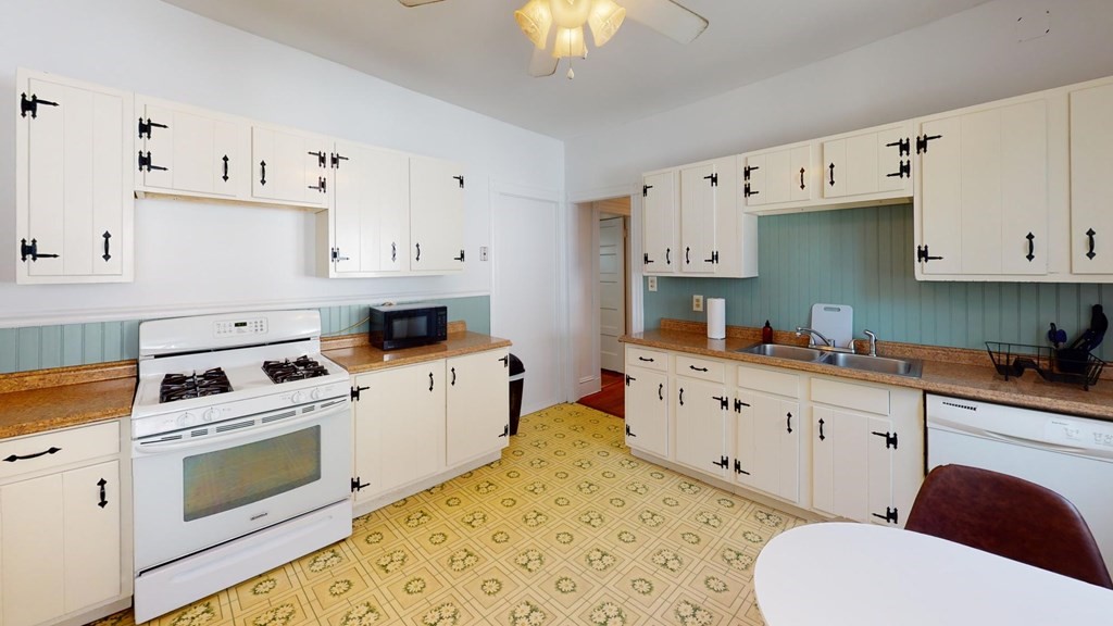 a kitchen with granite countertop a white cabinets and white appliances