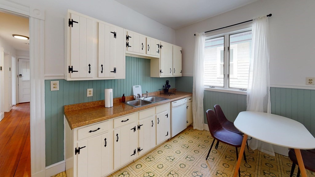 30 Roseclair Street, Unit 2 Boston, MA 02125 - Photo 4 of 14 a kitchen with stainless steel appliances kitchen island granite countertop a table chairs sink and cabinets