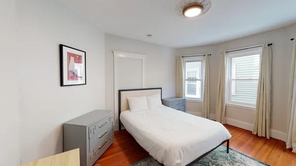 a bed sitting in a spacious bedroom next to a window