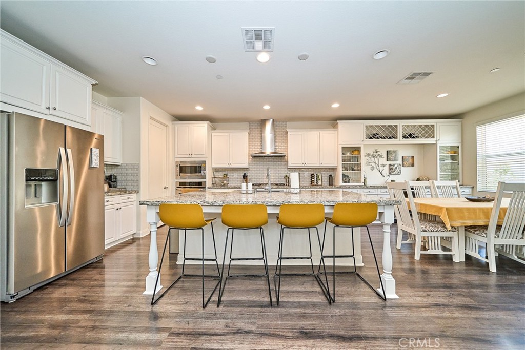 11568 Lark Drive Rancho Cucamonga, CA 91701 - Photo 11 of 20 a large kitchen with stainless steel appliances kitchen island granite countertop a table and chairs in it