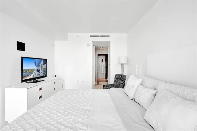 a bedroom with a bed and a flat screen tv