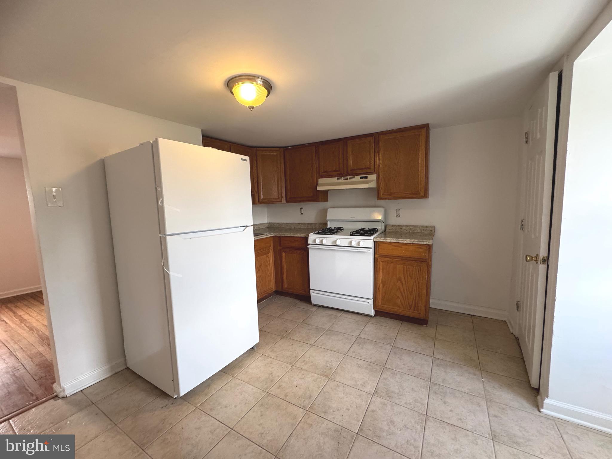 805 Brooks Lane, Unit 3 Baltimore, MD 21217 - Photo 7 of 9 a kitchen with a refrigerator a stove top oven and a window
