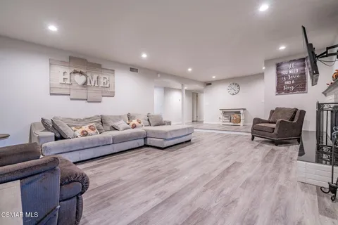 an empty room with wooden floor and a fireplace