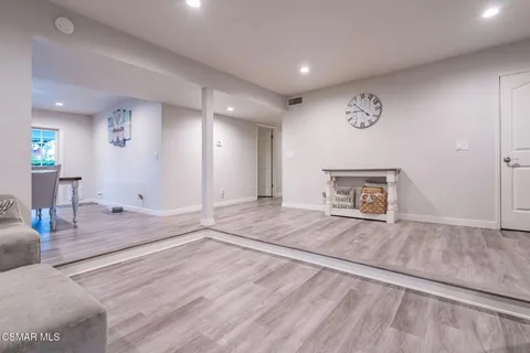 a kitchen with stainless steel appliances granite countertop wooden floor a dining table and chairs