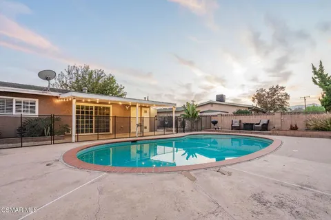a view of a house with a swimming pool and a yard