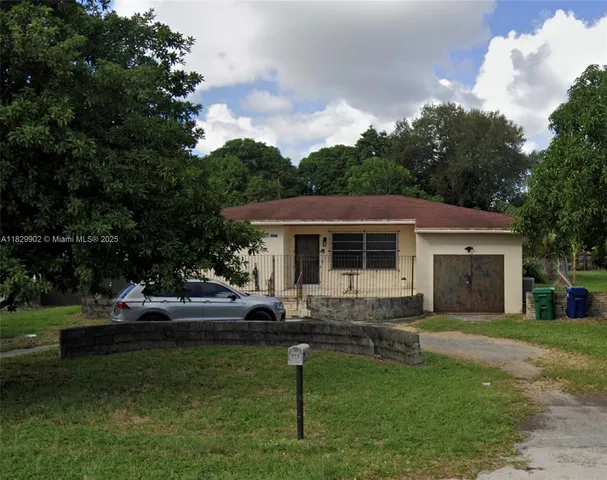 a front view of a house with a garden and trees
