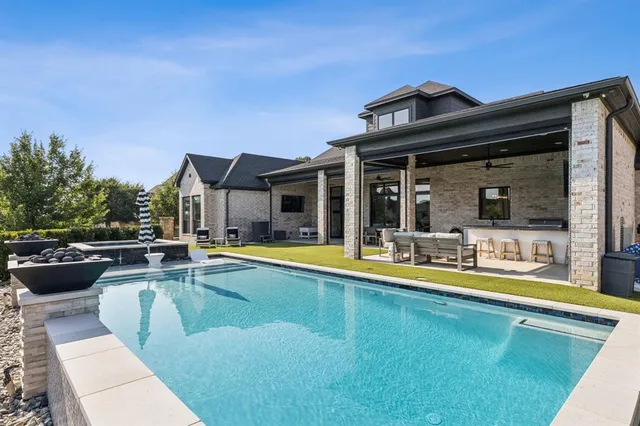 a view of a swimming pool with couches and lounge chairs