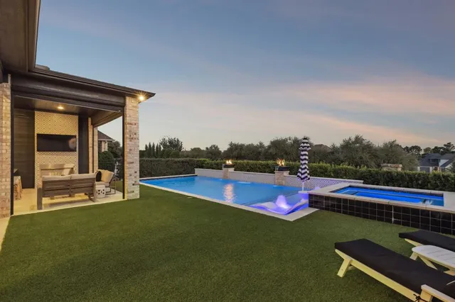 a view of a swimming pool with lawn chairs and a yard