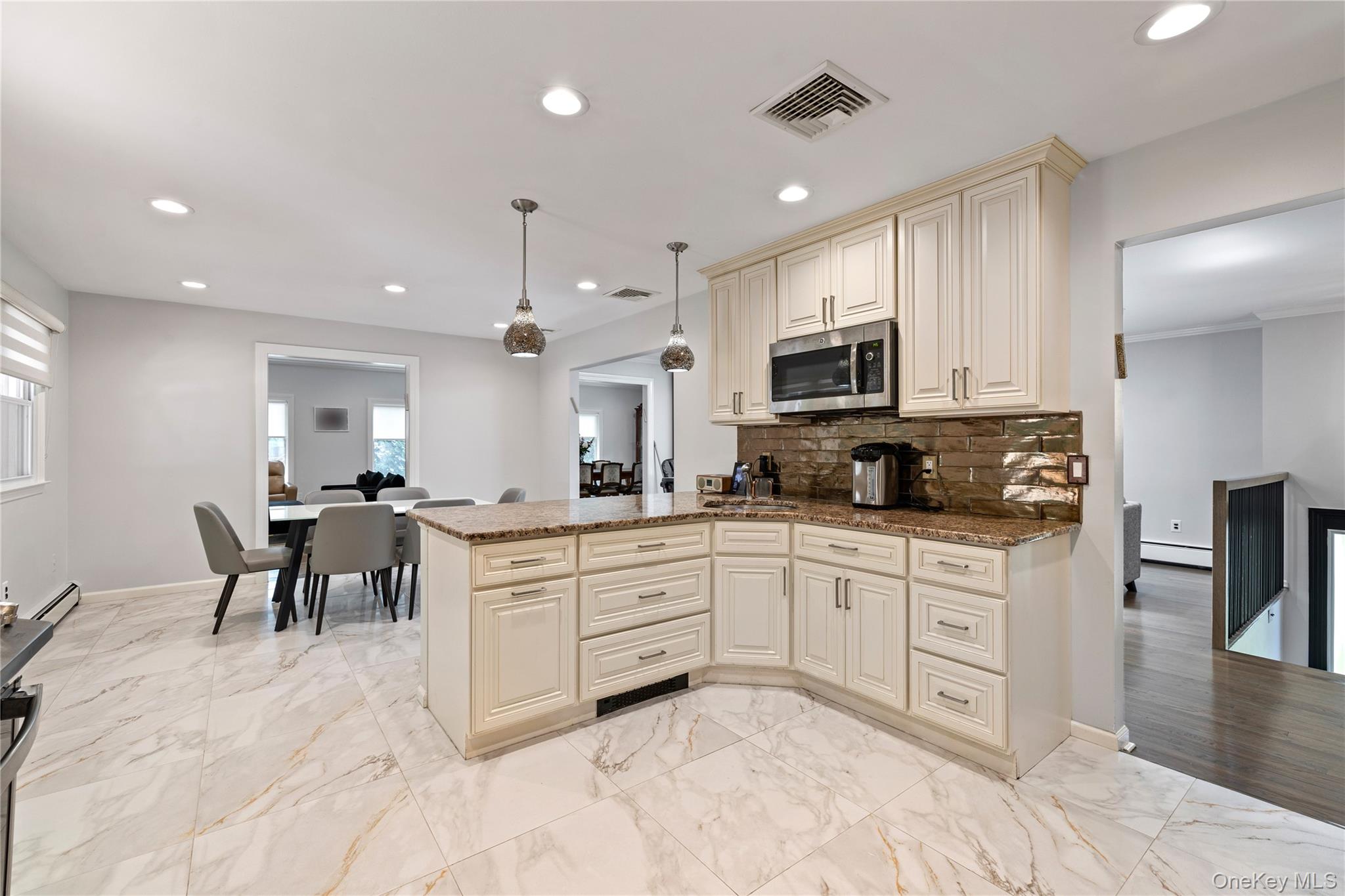 29 Skylark Drive Spring Valley, NY 10977 - Photo 17 of 44 a kitchen with stainless steel appliances granite countertop a stove top oven a sink a dining table and chairs with wooden floor