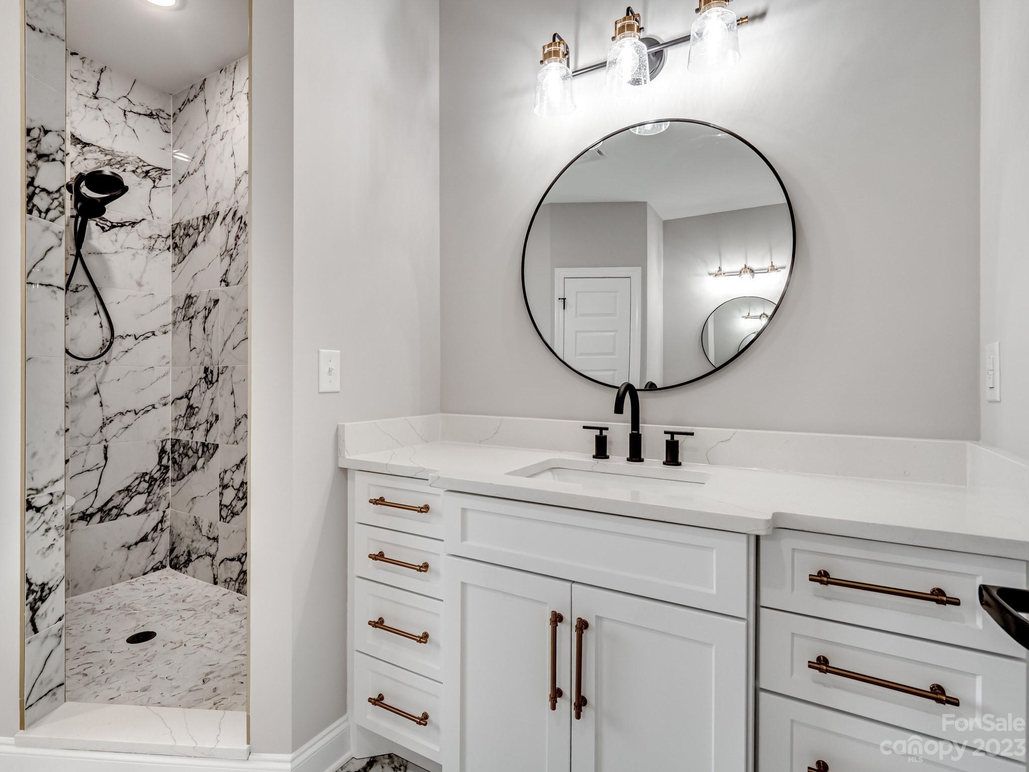213 9th Street Northeast Conover, NC 28613 - Photo 22 of 38 a bathroom with a sink a mirror and shower