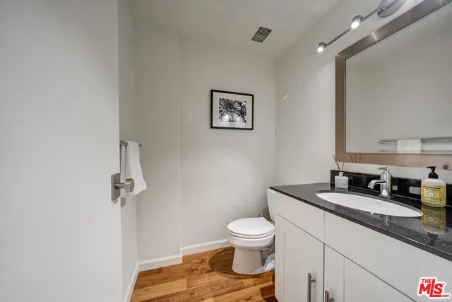 a bathroom with a granite countertop toilet and a sink