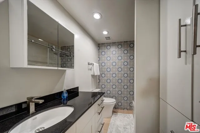 a bathroom with a granite countertop sink a mirror a shower and a bathtub