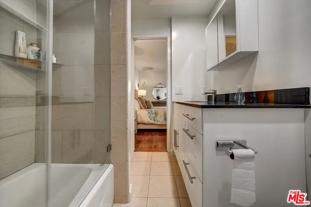 a bathroom with a granite countertop sink a toilet and shower